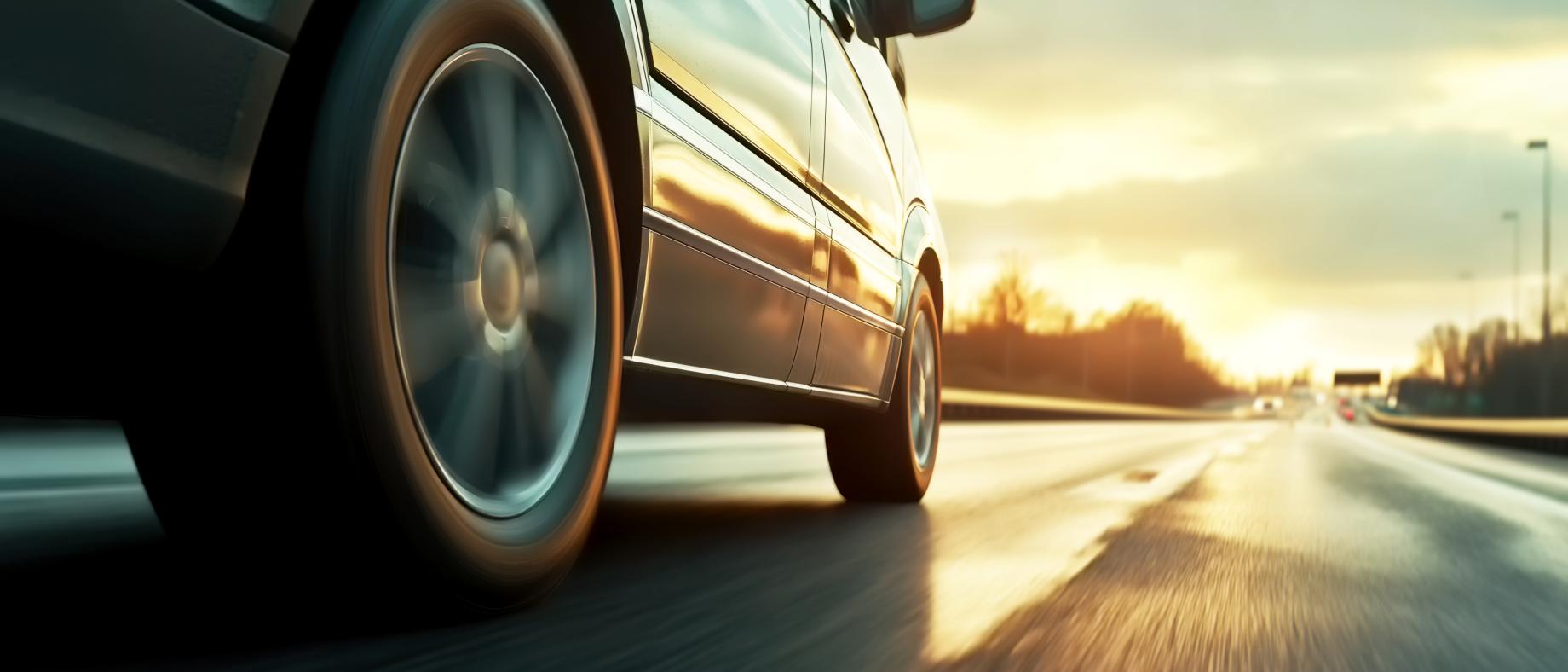 Voiture roulant sur la route, la photo est prise au niveau de la roue.
